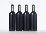 three bottles of wine sit side by side on a table