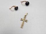 une paire de boucles d'oreilles et une croix sur un fond blanc
