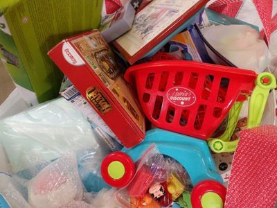 a basket full of toys and other items in a shopping cart