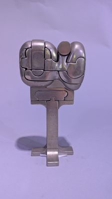 une sculpture métallique représentant un poing, posée sur un socle