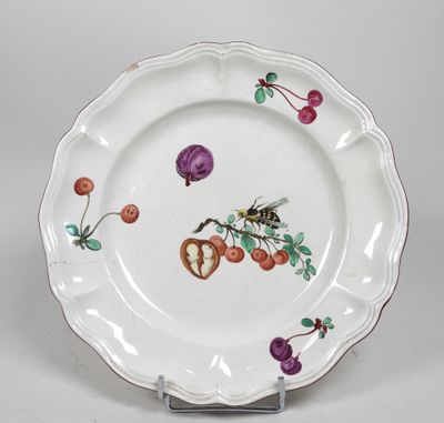 une image représentant une assiette blanche ornée d'un motif représentant un oiseau et des fruits