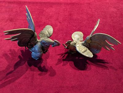 deux figurines représentant deux oiseaux sur un fond rouge