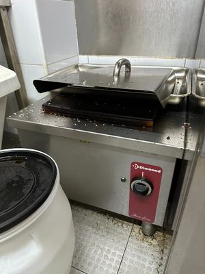 a small stove with a pan on it in a kitchen