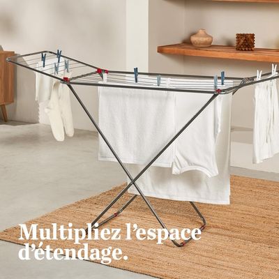 un étendoir à linge sur lequel sont suspendus des vêtements, dans une pièce