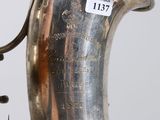 a silver vase with a bell hanging from it ' s side