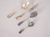 five silver spoons and two silver spoons on a white surface