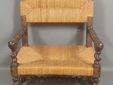 une image représentant une chaise en bois avec une assise tressée, sur fond gris