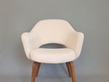 une chaise blanche avec des pieds en bois et une assise blanche