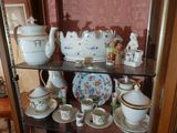 une vitrine en verre sur laquelle sont disposées de nombreuses tasses à thé et à café