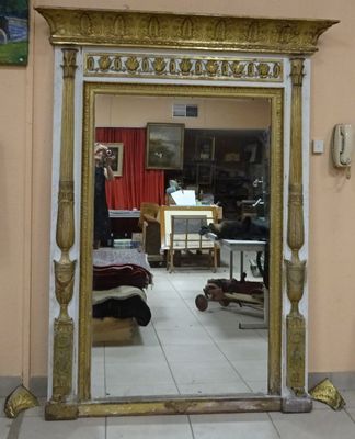 a mirror in the middle of a room with a painting on the wall