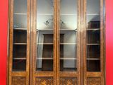 une photo d'une armoire en bois avec des portes vitrées, posée sur un sol carrelé