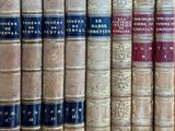 several old books are lined up on a shelf in a library