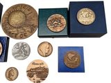 some of the coins are in a blue box on a white surface