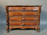 an image of a small wooden chest of drawers on a grey background