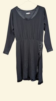 the dress is black and has a long sleeve and a side tie