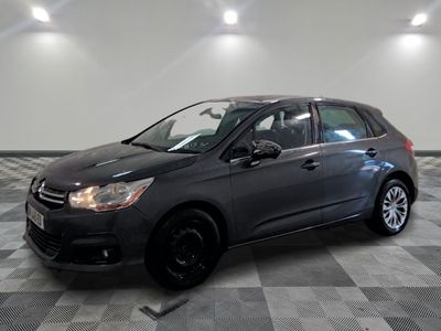 Une voiture grise est garée dans une pièce dont le sol est en damier.