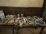 a table with a lot of silver spoons and silverware on it