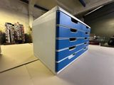 a stack of blue drawers sitting on a table in a warehouse