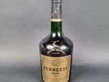une vieille bouteille de whisky Hennesby sur fond gris