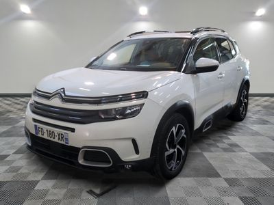 Le SUV Citrole blanc est garé dans une grande pièce.