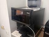 a microwave and a printer on a shelf in a room