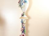 a tall vase with a woman on it sitting on a table