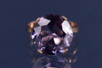une bague en améthyste ornée d'une pierre violette en son centre