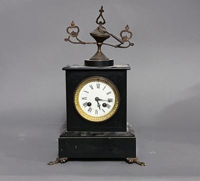 une horloge noire surmontée d'un oiseau