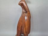 wooden sculpture of a woman with a hat on her head