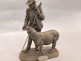 une statue représentant un homme avec un chien et un mouton