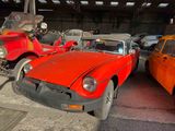 Plusieurs vieilles voitures sont garées les unes à côté des autres dans un garage.
