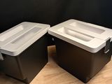 two black and white storage boxes on a wooden surface