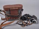 a camera and a pair of binoculars on a table