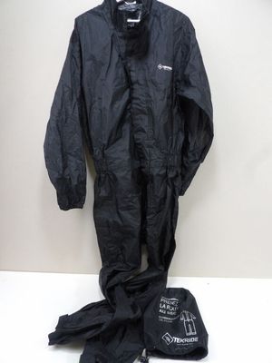 un imperméable noir et une paire de chaussures posés sur une table blanche