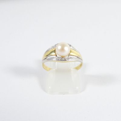 une image d'une bague en perles et diamants sur une surface blanche