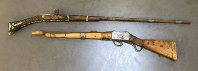 two old weapons are sitting on a table next to each other