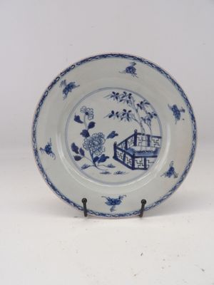 a blue and white plate with a bird and flowers on it