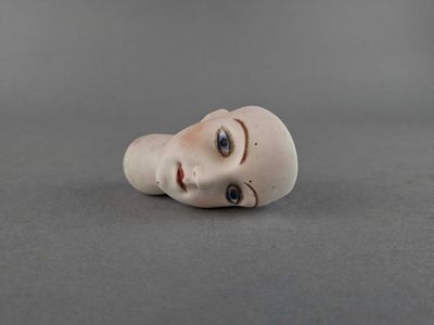 a small doll head that is on a table