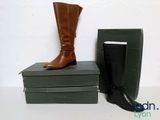 a pair of boots sitting on top of a stack of books