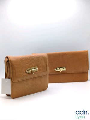 two tan leather wallets with a gold clasp on each of them