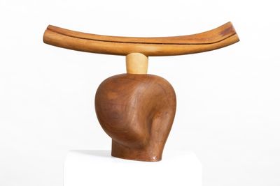 a wooden sculpture of a man ' s head on top of a table