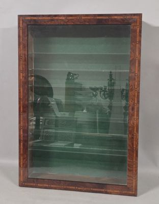 an old picture of a man and a woman sitting at a table in a glass case