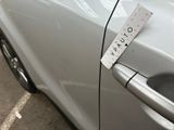 a sticker on the door handle of a car that is parked in a parking lot