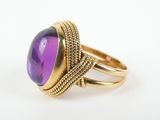 a close up of a ring with a purple stone on it