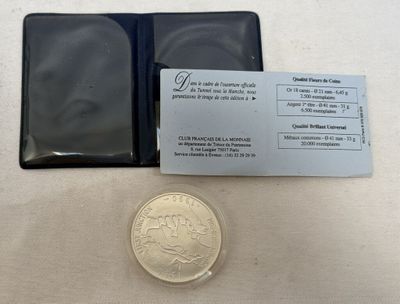 une petite pièce posée à côté d'un portefeuille sur une table