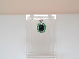an image of a pair of emerald earrings on a clear display case