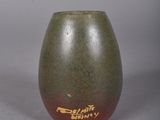 a green vase with a red and yellow design on it