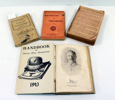 Plusieurs vieux livres sont posés sur une table où se trouvent d'autres vieux livres