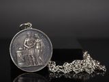 a close up of a coin on a chain on a table