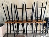 Dans une pièce, plusieurs chaises sont alignées contre un mur de briques.
